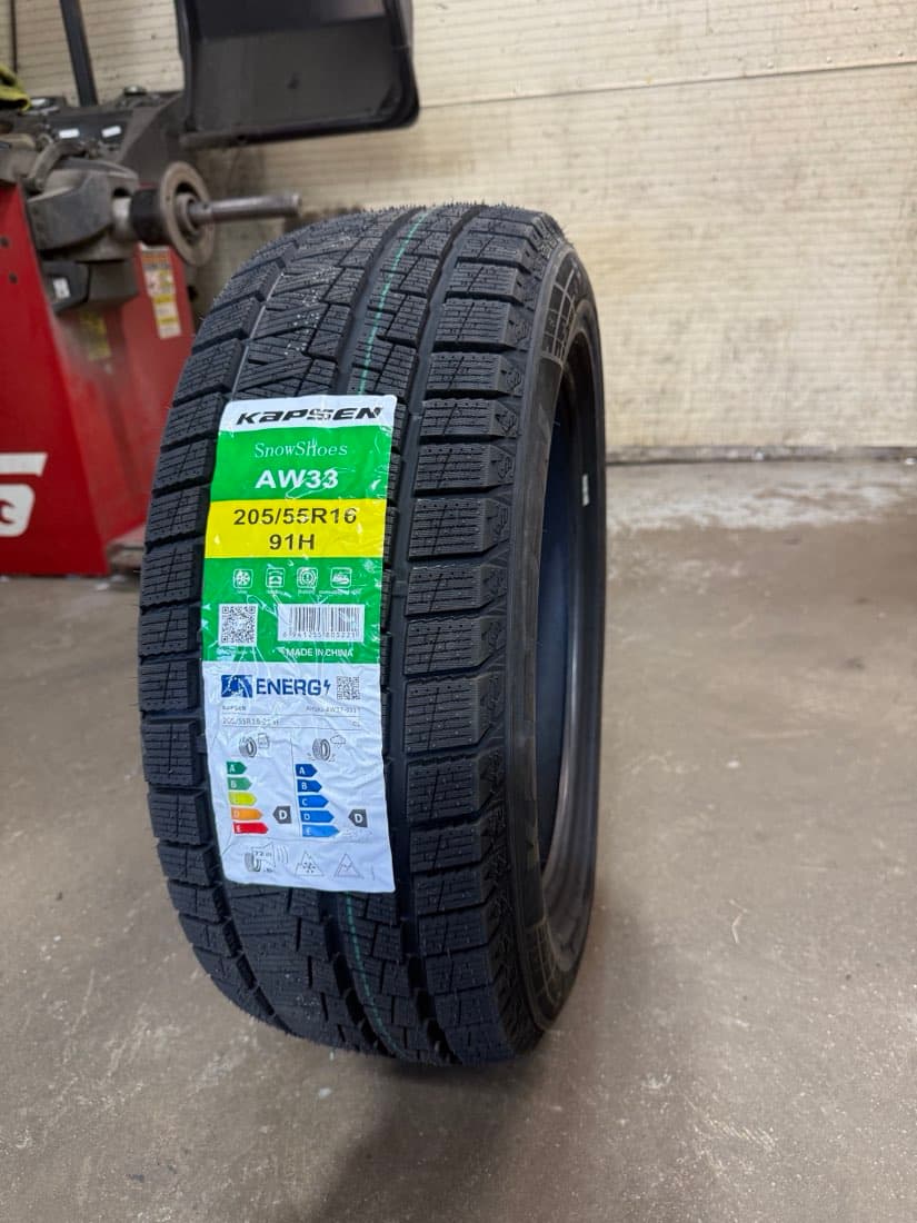A new Kapsen SnowShoes AW33 winter tire in 205/55R16 with its label, in the Techtire shop